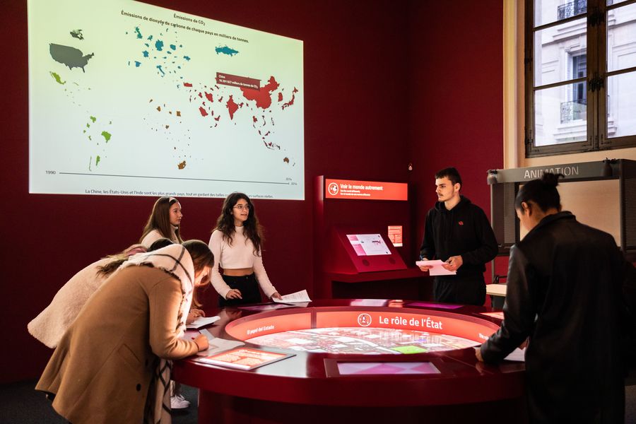 Lycéens en visite autour de la table interactive Le rôle de l’État